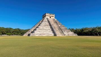 Ancient Mayan pyramid in Chichen Itza, Mexico, surrounded by lush greenery and clear skies photo