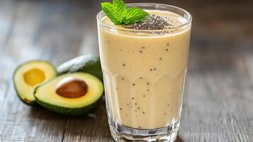 Creamy avocado smoothie tall glass garnished with mint and chia seeds, refreshing and nutritious photo