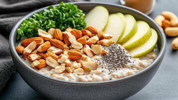 nutritious breakfast bowl featuring oatmeal topped with almonds, chia seeds, fresh apple slices photo