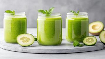 Refreshing green smoothies in jars with cucumber slices and mint leaves photo