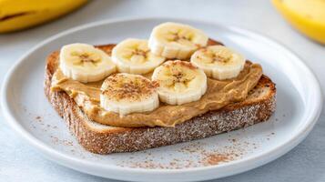 Creamy nut butter spread whole grain toast topped with fresh banana slices creates delicious photo