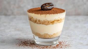 Creamy tiramisu dessert layered with coffee and cocoa, topped with coffee bean photo