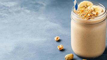 Creamy peanut butter smoothie topped with banana and crushed nuts, perfect for healthy snack photo