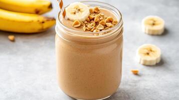Creamy peanut butter protein shake topped with banana slices and nuts, perfect for healthy boost photo