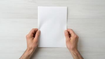 person holding blank sheet of paper with both hands, conveying sense of anticipation or photo