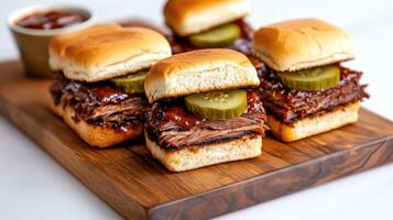 Delicious brisket sliders topped with pickles and barbecue sauce on wooden platter photo