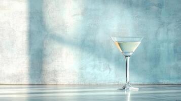 cocktail glass filled with clear drink sits elegantly reflective surface against soft blue wall photo