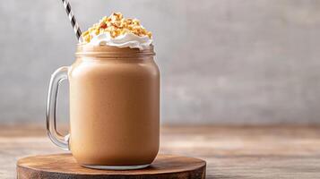 Creamy peanut butter milkshake in mason jar topped with whipped cream and nuts photo