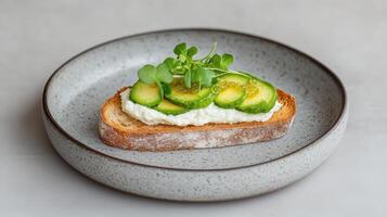 Creamy cheese spread on toasted bread topped with fresh cucumber slices and microgreens photo