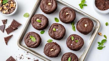 Delicious molten lava cakes arranged on tray, garnished with mint leaves and nuts photo