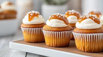 Delicious vanilla cupcakes topped with caramel drizzle and sea salt, perfect for any occasion photo