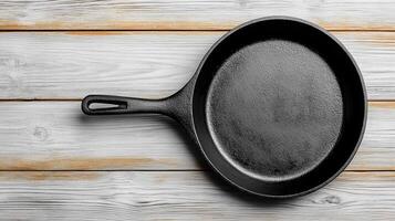 classic black cast iron pan rests on rustic wooden surface, showcasing its timeless design photo