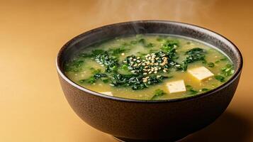 steaming bowl of miso soup with seaweed, tofu, and sesame seeds creates warm, comforting photo