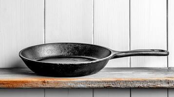time worn cast iron pan resting on rustic wooden shelf, showcasing its vintage charm photo