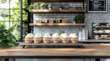 Freshly made cupcakes displayed on tray in cozy cafe, surrounded by greenery and warm decor photo