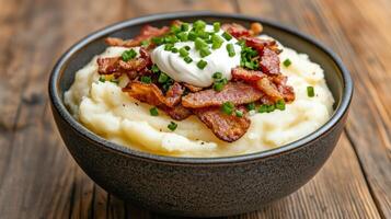 Creamy mashed potatoes topped with crispy bacon and chives create delicious comfort dish photo