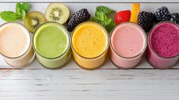 Colorful smoothie lineup featuring fresh fruits and mint leaves, perfect for refreshing treat photo