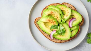 Creamy avocado toast topped with spices and fresh herbs on whole grain bread photo