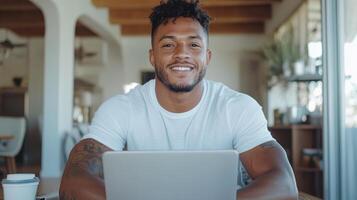 Confident young man smiling at laptop in bright workspace, showcasing positive attitude photo