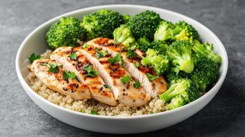 Grilled chicken breast served with quinoa and fresh broccoli, healthy and delicious meal option photo