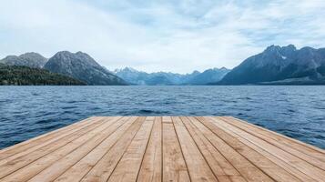 serene wooden dock extends over tranquil lake, surrounded by majestic mountains and cloudy sky photo
