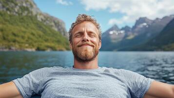Relaxed man enjoying serene moment on lake surrounded by mountains and nature beauty photo