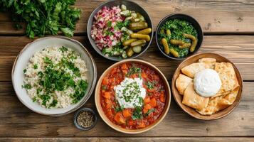 Delicious borscht served with rice, pickles, and fresh herbs creates vibrant meal photo
