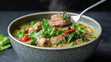 delicious bowl of soup with tender meat, fresh herbs, and vibrant vegetables, steaming with photo