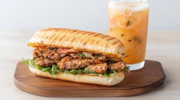 Crispy sandwich filled with seasoned meat, fresh vegetables, and refreshing drink photo