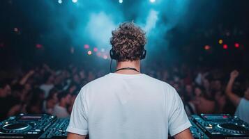 DJ performing in vibrant club atmosphere, surrounded by energetic crowd photo