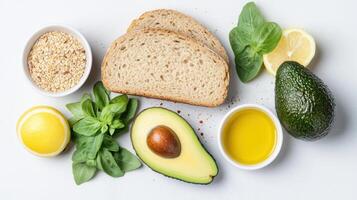 Fresh ingredients for healthy meal, including whole grain bread, ripe avocado, and lemon photo