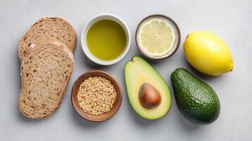 Fresh ingredients for healthy meal preparation, including whole grain bread, avocados, and oils photo