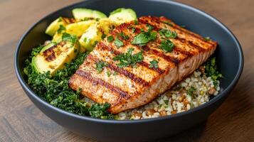 Grilled salmon fillet served with quinoa, kale, and grilled avocado, creating nutritious meal photo