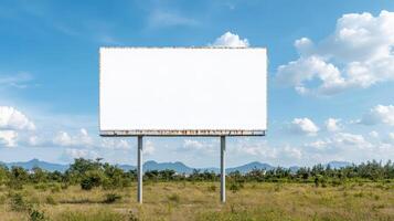 large blank billboard stands open field bright blue sky with fluffy clouds, surrounded by photo