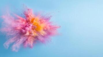 vibrant explosion of colorful powder creates mesmerizing effect against light blue background photo