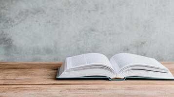 open book rests on wooden table, showcasing its pages against textured gray background photo