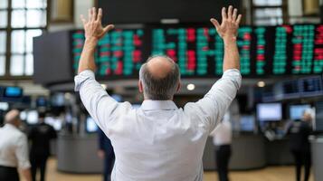 Traders celebrating successful day on stock exchange floor with raised hands photo