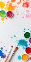 Assortment of vibrant watercolors with brushes on a splattered canvas creating an artistic background photo