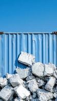 Blue shipping container with rubble against clear sky photo