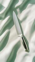 Sleek chef's knife on elegant fabric in gentle light and shadows photo