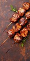 Close up of grilled pork skewers on rustic background with fresh rosemary garnish photo
