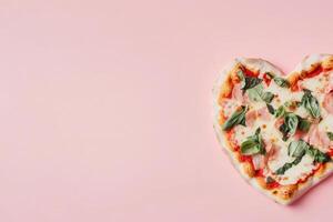 Heart shaped pizza with fresh basil and mozzarella on light pink background photo