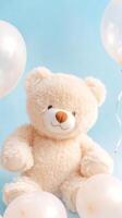 Fluffy white plush bear surrounded by pearlescent balloons against a light blue background photo