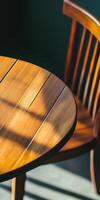 Sunlit wooden table and chair with warm tones and shadows in minimalist setting photo