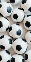 Cluster of classic black and white soccer balls in a neat arrangement on a white surface photo