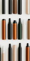 Assorted sleek vape pens arranged in rows against a minimalist white background photo