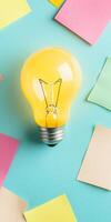 Bright yellow lightbulb on colorful sticky notes background with creative ideas and innovation concept photo