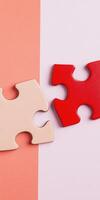 Two puzzle pieces connecting on a pink background symbolizing unity and problem solving photo