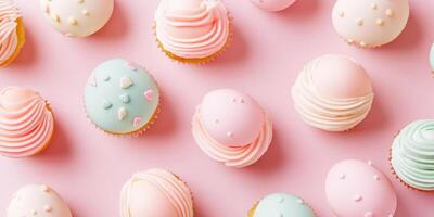 Colorful cupcakes with decorative frosting on a pink background creating a pattern of sweet delight photo