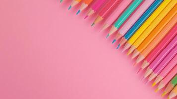 Colorful array of pencils aligned on pink background for artistic inspiration and creativity photo